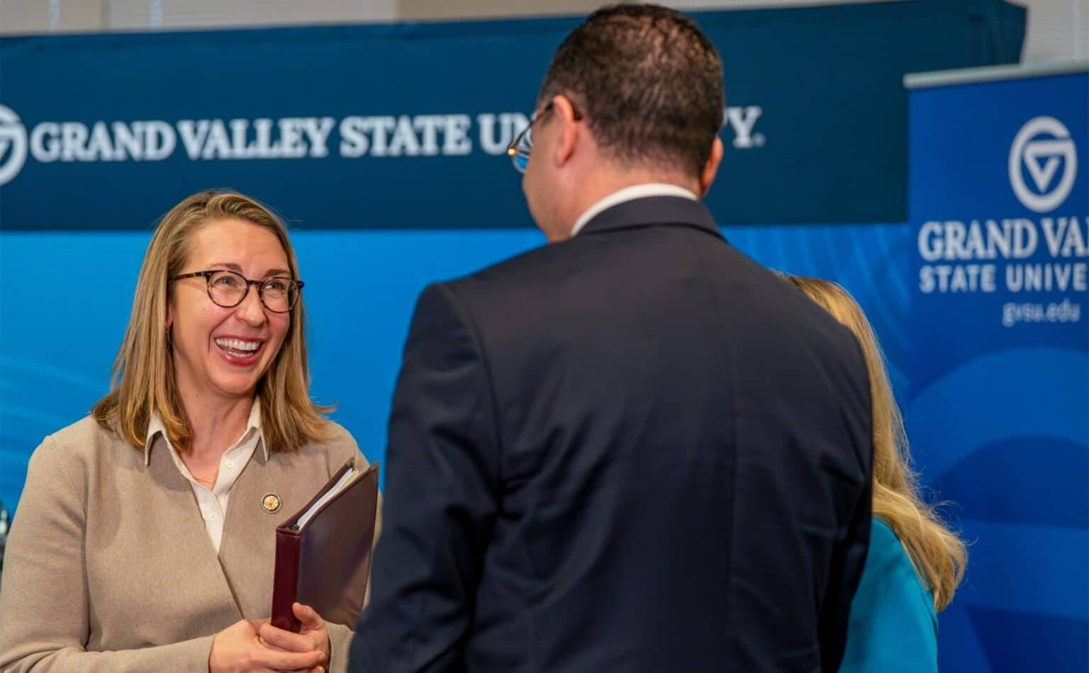 U.S. Rep. Hillary Scholten speaks with College of Computing Dean Marouane Kessentini after a press conference.